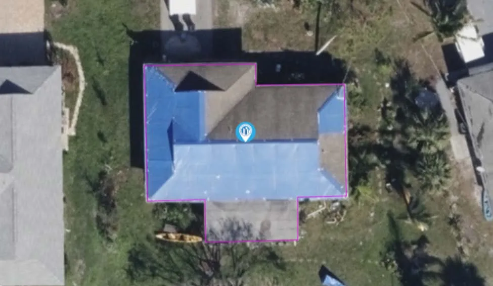 The same roof under a blue tarp after damage, recent capture
